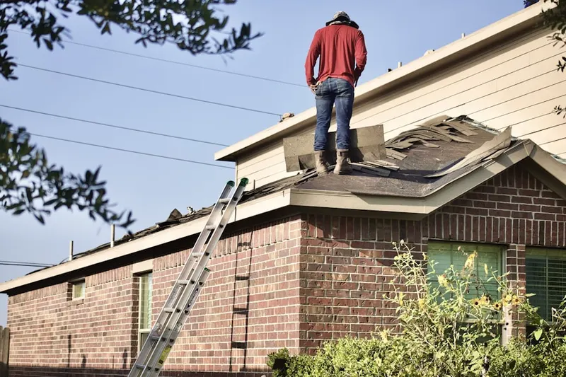 Professional roofer working on a residential roof in Brown